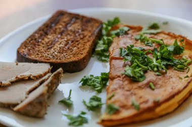 Kahvaltı, pastırma, maydanoz ve che ile bir tabakta çırpılmış yumurta