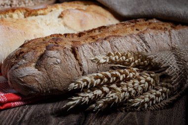 Ahşap masa arkasında pişmiş ekmek çeşitleri