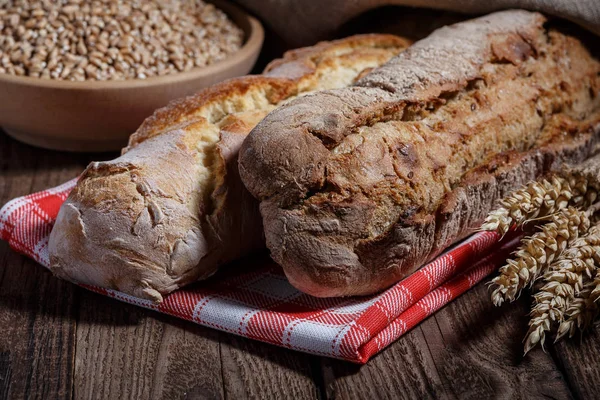 Ahşap masa arkasında pişmiş ekmek çeşitleri