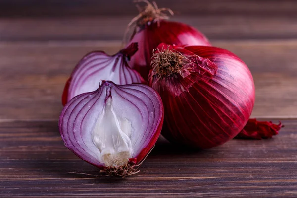 Cebollas rojas en madera rústica.Cebollas rojas orgánicas frescas en una madera b — Foto de Stock