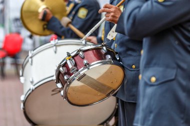 Yürüyüş bandosu davulcuları geçit töreninde çalıyor, adam müzik yapıyor.
