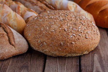 Ahşap masa arkasında pişmiş ekmek çeşitleri