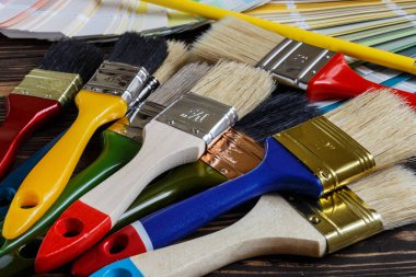 Boyacı ve dekoratör, ev projeleri, renk örnekleri ve boya fırçaları ile çalışma masası.