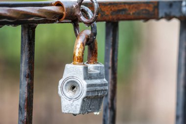 Kapıda paslı asma kilit var. Kapalı eski kilitli kapı. Izgara çitin kapalı kilidi.