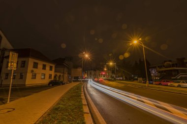 Klatovy yeni sokak turuncu gökyüzü ile sonbahar gece otomobillerde ve sokaklarda ışıkları ile