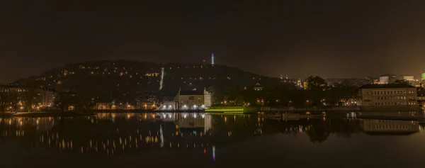 冬の暗い夜にヴルタヴァ川の近くの首都プラハの中心部 — ストック写真