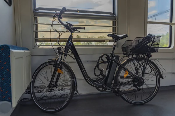 Black electric bicycle in czech train in sunny spring afternoon