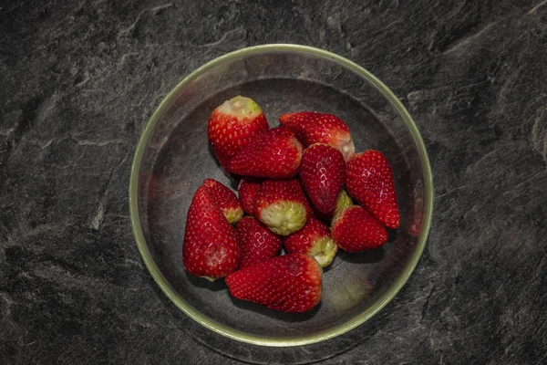 Fazendo de morangos com açúcar na mesa preta na cozinha de telha branca — Fotografia de Stock