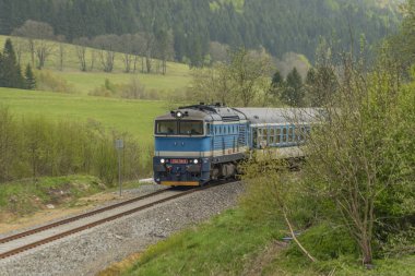 Jeseniky dağlarda yolcu antrenörü ile Mavi dizel tren