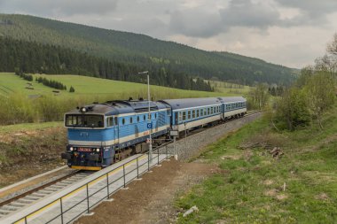 Jeseniky dağlarda yolcu antrenörü ile Mavi dizel tren