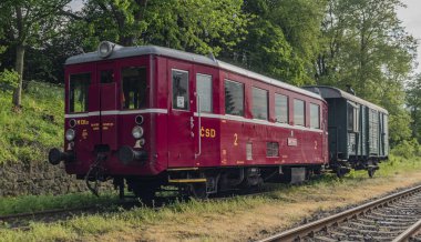 Ceska Kamenice kasabasında kargo yeşil araba ile Kırmızı eski tarihi dizel tren