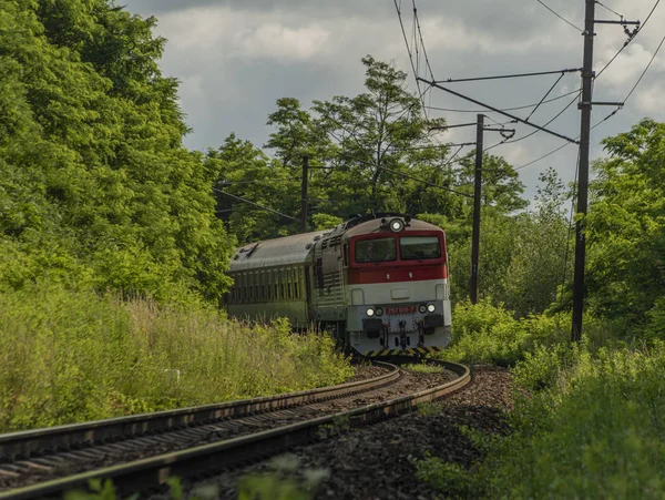 Grand train de passagers diesel rouge près de la gare de Kysak en été matin chaud — Photo