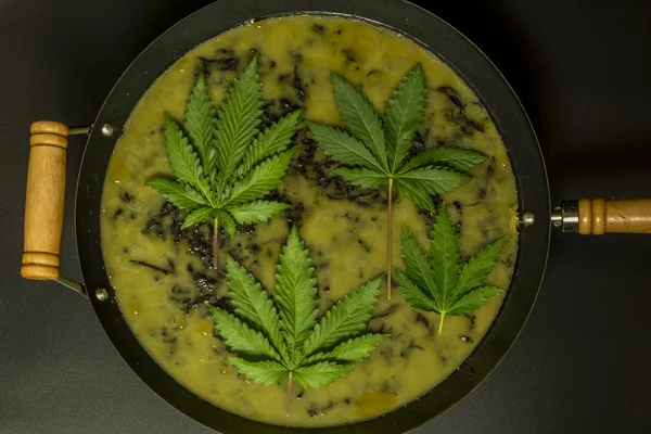 Wok siyah arka plan ile marihuana yağı yapımı