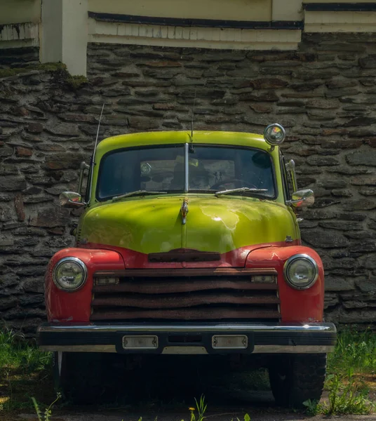 春の晴れた日に銀赤黄色と石の壁と古い古典的なベテランの車 — ストック写真