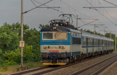 Moravya 'nın güneyindeki hızlı demiryolunda elektrikli mavi motor ve koçlar.