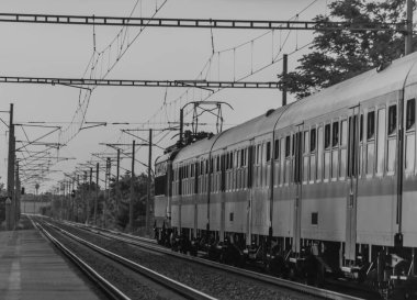 Siyah beyaz lektrik mavi motor manzarası ve hızlı tren yolu koçları.