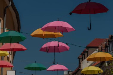 VIllach şehrinde yaz güneşli sabahlarında mavi arka planda gökyüzü olan renkli şemsiyeler.