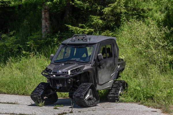 Black caterpillar snow car on asphalt road in summer hot day in Kanzelhohe area in Austria