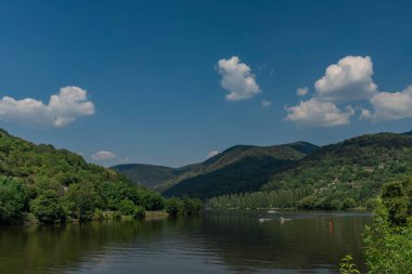 Kuzey Bohemya 'daki Sebuzin köyünde nehir labradoru vadide güneşli mavi bir gün.