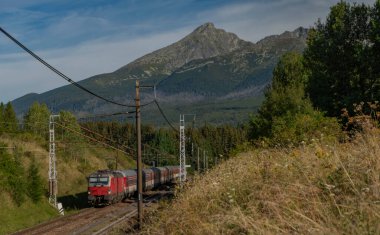 Vysoke Tatry Ulusal Parkı yakınlarındaki Slovakya 'daki ana demiryolunda kırmızı hızlı yolcu treni