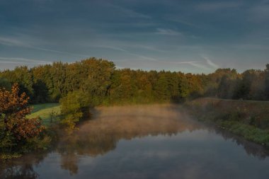 Bisiklet köprüsü ve küçük limanı olan Vltava Nehri yaz mevsiminde soğuk bir sabah ve gün doğumuyla