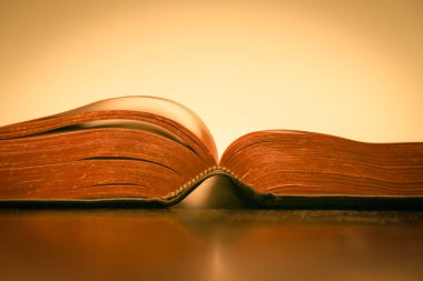 Sarı arkaplan üzerine İncil 'in sayfaları. Altınla işaretlenmiş kutsal kitap.