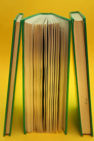 Book standing vertically over a yellow background — Stock Photo, Image