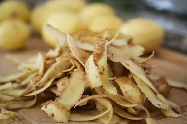 Φλούδες πατάτας, ξεφλουδίζοντας μια στοίβα πατάτες με φλούδες σε πρώτο πλάνο — Φωτογραφία Αρχείου