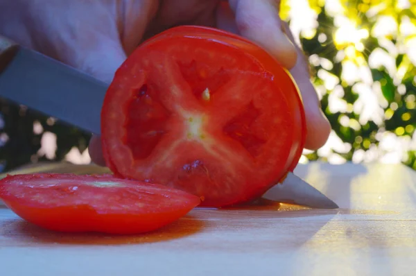 Zbliżenie Krojenie Pomidora Ręką Nożem Pokładzie Cięcia Tle Drzew Zachód Obrazy Stockowe bez tantiem