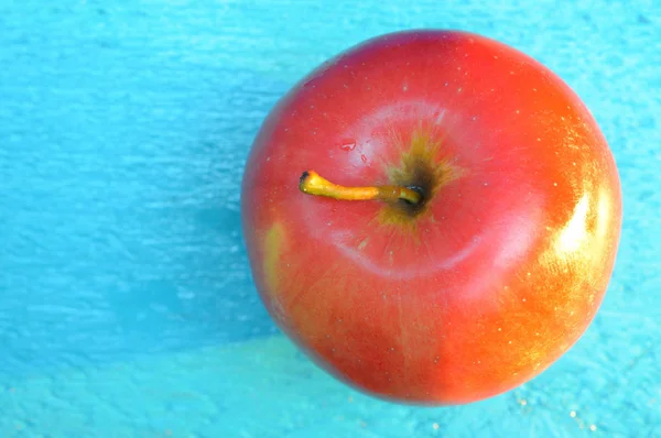 Κόκκινο Μήλο Ένα Ξύλινο Τραπέζι Ξύλινο Γαλάζιο Τυρκουάζ Φωτίζονται Από — Φωτογραφία Αρχείου