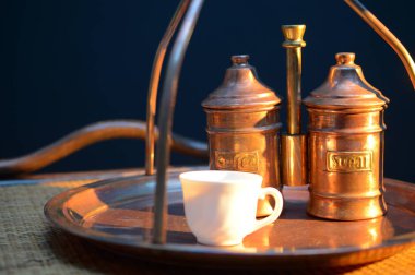 sugar Bowl'dan ve kapsayıcı yakınındaki kahve kahve bakır tepsi ve rattan masa