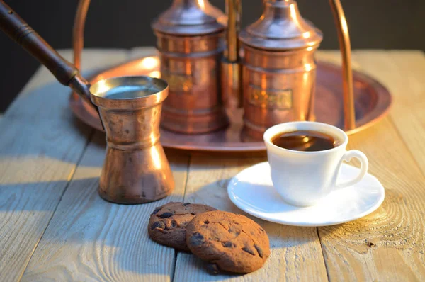 a biscuits and a Cup of coffee near the sugar bowl and a container with coffee on rustic wooden table