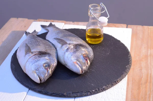 Рыба дорадо на черной тарелке с — стоковое фото