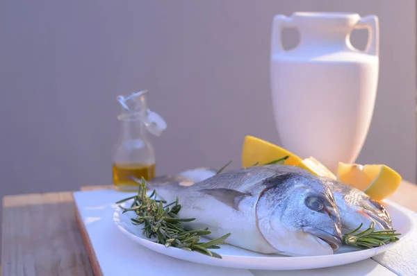 Dorado pescado en un plato negro y mesa de madera — Foto de Stock