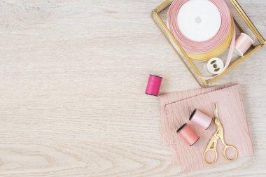 Mat pembe ile kompozisyon renkler dikiş ipliği ve Aksesuar ahşap arka plan, üstten görünüm