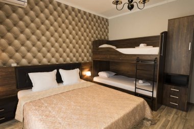 Klas otel yatak odası iç tasarım. Büyük yatak, ranza yatak. Aile Odası-kahverengi renk tonu mobilya  