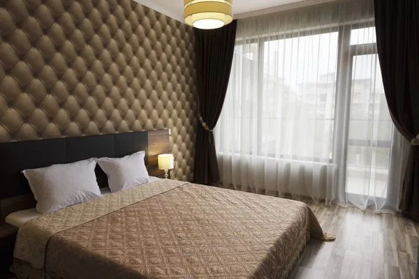 Stijlvolle slaapkamer interieurontwerp. Groot bed, kamer met bruin kleurtoon. Windows met lange gordijnen, gordijnen en rieten — Stockfoto