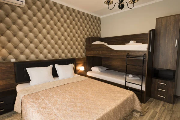 优雅的酒店卧室室内设计。大床, 双层床。带棕色色调家具的家庭间 — 图库照片