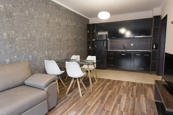 Wohnzimmer mit offener Küche. Neue Heimat. Zimmer mit Möbeln in Brauntönen. Innenaufnahmen. Holzboden — Stockfoto