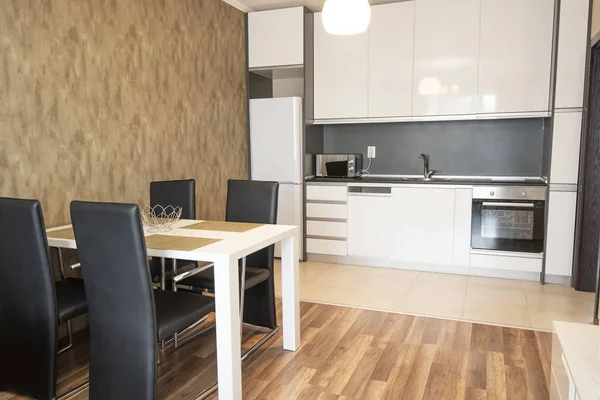 Mesa de comedor con juego de sillas cerca de la gran ventana en la cocina —  Fotos de Stock