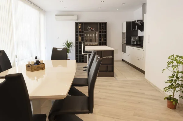 Mesa de comedor con juego de sillas cerca de la gran ventana en la cocina. Fotografía interior. Espacio abierto sala de estar con cocina — Foto de Stock