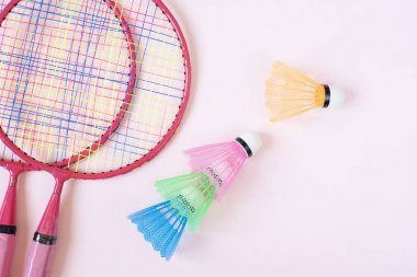 Badminton ekipmanları. Badminton raketleri ve pembe arka plan üzerinde shuttlecock. Üst görünüm, kopyalama alanı