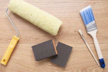 Ahşap arka plan üzerinde fırçalar ve silindirler boyama. Yüzeyleri boyamak için yapı araçları