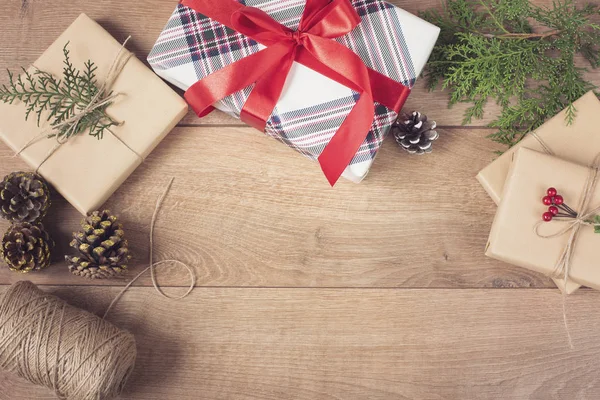 Fundo de Natal com decorações e caixas de presente em tábua de madeira. Cenário festivo para férias de inverno — Fotografia de Stock