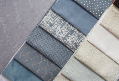 Masadaki kumaş örnekleri. Tasarımcı işyeri konsepti. Gri arka plan üzerinde düz yatıyordu tarzı serbest moda rahat kadınlık çalışma alanı. Üst görünüm, mavi renk paleti