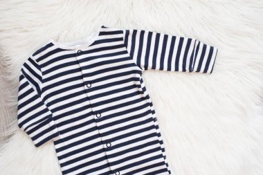 Bebek Maket. Beyaz ve Siyah Çizgili Bodysuit. Tulum, Romper Beyaz Kürklü Halı. Yenidoğan Bebek Kavramı. Bebek Erkek ya da Kız Kıyafetleri. Boşluk Kopyala, Üstte Görüntüle