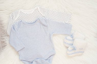 Bebek Bodysuit Mockup. Tarz Stok Fotoğrafçılık. Bir erkek için kıyafet. Tulumlar, Beyaz Kürklü Halıda Rompers. Yenidoğan Bebek Kavramı. Erkek Bebek Giyim Seti