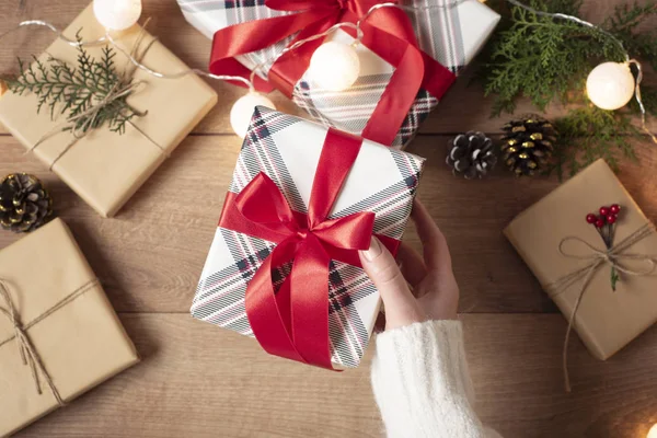 Caja de regalo de mano femenina. Mujer Embalaje regalos de Navidad. Vista superior, plano laico, regalo de Adviento. Vacaciones de invierno Fondo Imagen De Stock