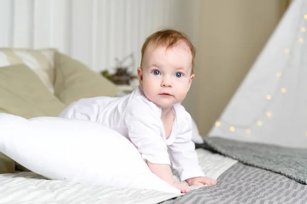 Kız yatakta beyaz bir elbise içinde yarım yıl yaşında