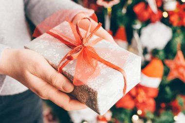 Noel hediyesi bulanık Noel ağacı arka planda tutan kadın el görünümü Kapat 